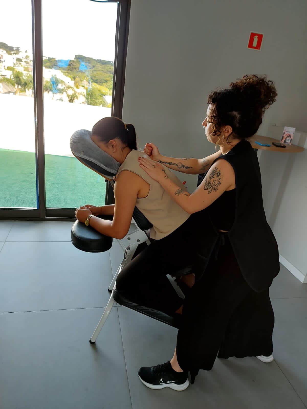 Laura aplicando quick massage em uma profissional no escritório